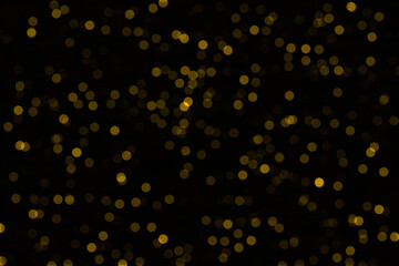 Yellow bokeh on a black background. Glare to decorate the photo.