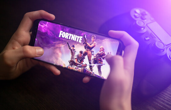 February 8, 2021: Phone In Hand With The Fortnite Logo On A Background Of Changing Graphics.