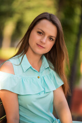 Portrait of a young charming girl in the summer park.