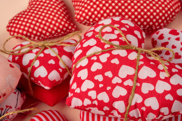 Handmade red, stripy, cross hatchet hearts tied with a rope in pairs on a pale pink background. St. Valentin's Day, Mother Day, Birthday.