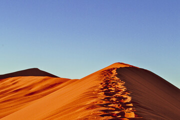 Fototapeta na wymiar Footprints atop Namibian desert dunes