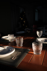 white plates, wineglasses, knifes and forkes on wooden table. Top view.