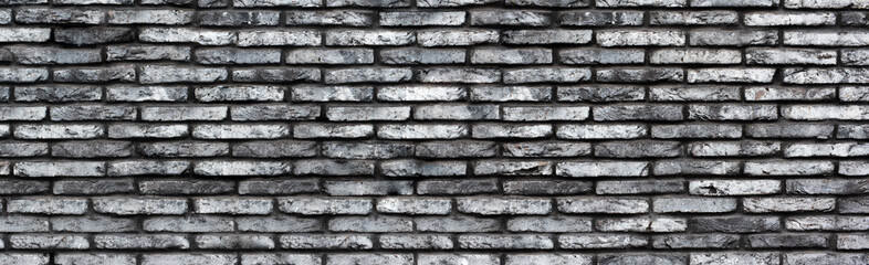Gray grunge brick wall background. Banner. Wide wall texture of rough brickwork for design.