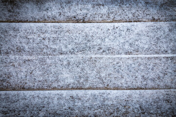 Old wooden board covered with white fresh snow . Flat lay. Christmas winter background.