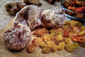 figs and raisins on wooden tray, selective focus
