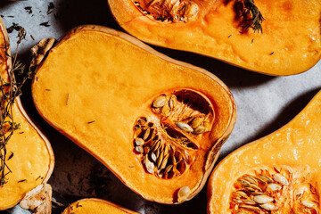 Roasted pumpkins with thyme herbs on baking sheet