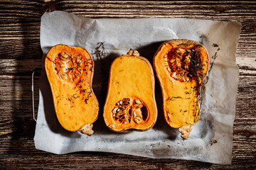 Roasted pumpkins with thyme herbs on baking sheet