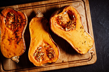Roasted pumpkins with thyme herbs on cutting board