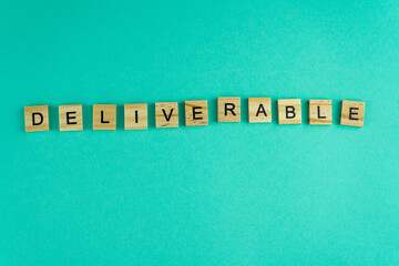 Word deliverable. The phrase is laid out in wooden letters. Top view. Motivation. Blue background....