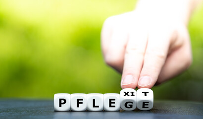 Symbol für die Kündigung vieler Pflegekräfte. Hand dreht Würfel und ändert das Wort 