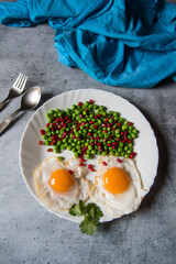 Poached eggs and freshly steamed vegetables in a plate. Top view, selective focus.