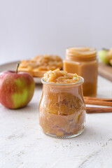 Jar of sweet apple jam on light background