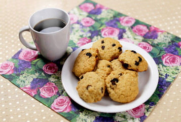 Breakfast served on the table, a cup of coffee with oatmeal cookies
