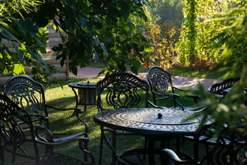 Garden chairs and table metal openwork forged in the summer garden