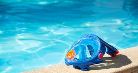swimming mask with snorkel near the blue pool on a sunny tropical morning - obrazy, fototapety, plakaty
