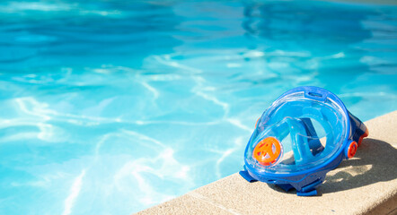 swimming mask with snorkel near the blue pool on a sunny tropical morning