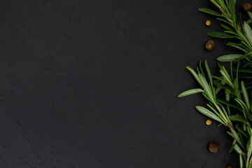 Fototapeta na wymiar rosemary sprigs and allspice seeds are laid out on a stone board background image food photo