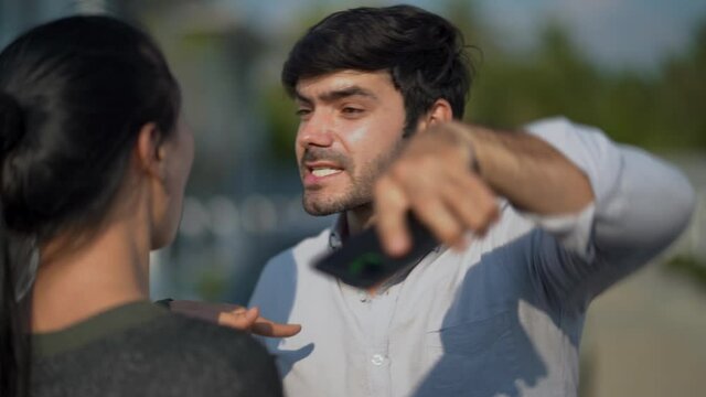 Two angry motorists arguing after a car accident on the road calling insurance company on mobile phone to responsibility for car accident traffic collision. furious driver man shouting to stress woman
