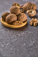 Walnut in wooden bowl on black background with copy space