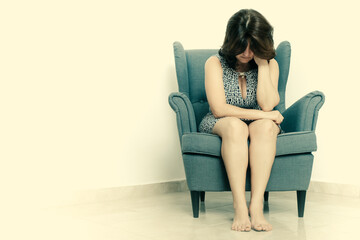 Stressed and sad  woman sitting alone on a chair