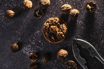 Obraz na płótnie Canvas Vintage walnut cracker and walnuts on a dark texture background.