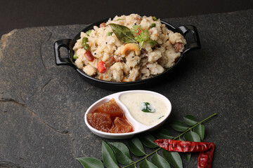 Rice upma, a south Indian vegetarian breakfast made from shredded rice and vegetables like carrot andpeas, with coconut chutney as a side dish.