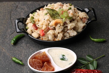 Rice upma, a south Indian vegetarian breakfast made from shredded rice and vegetables like carrot andpeas, with coconut chutney as a side dish.