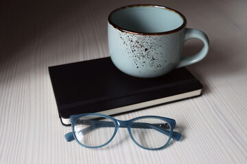 Large handmade ceramic mug, notepad for note-taking and sketching, blue glasses for vision. Items for comfortable work from home and freelancing. 