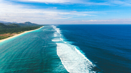 Long beatiful beach with white sands and blue sea water. Beautiful aerial view with long waves.