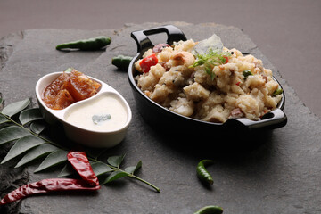 Rice upma, a south Indian vegetarian breakfast made from shredded rice and vegetables like carrot andpeas, with coconut chutney as a side dish.