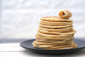 stack of classic american pancakes on a wooden rack. traditional family breakfast. comforting pancakes. front view. good morning concept.