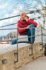 Concept of business, technology, communication and people - smiling businessman with smart phone talking on city background.