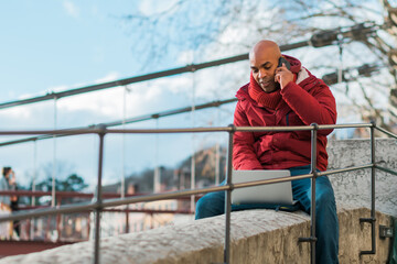 Concept of business, technology, communication and people - smiling businessman with smart phone talking on city background.