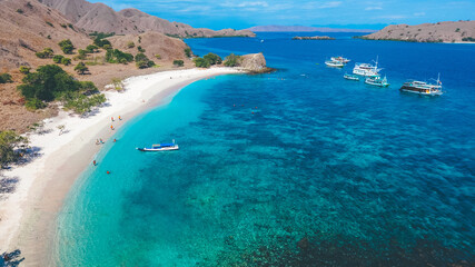 Aerial view of white sand beach in Pink Beach, Labuan Bajo, Indonesia. Sailing boat in Komodo National Park.