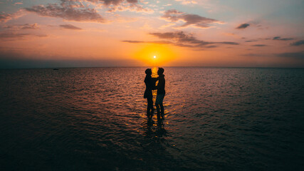 Silhouette of a happy loving couple at sunset on the seashore