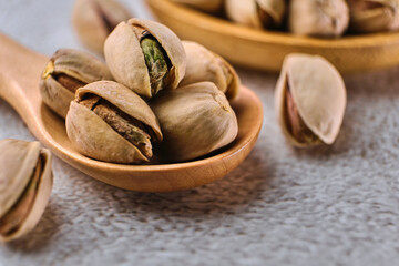 Organic pistachio nuts in bowl on table.