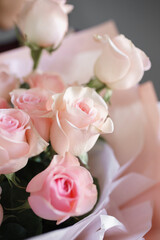 image of a girl in apron holding a flower in her hands with a manicure on a grey background	