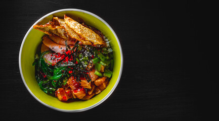Fresh seafood recipe. Shrimp salmon poke in bowl on black wooden table background