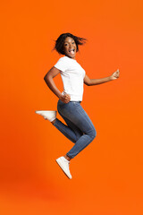 Fototapeta na wymiar Joyful young black woman posing on orange