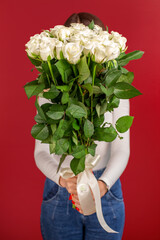 The girl with big bouquet of white roses in front of her