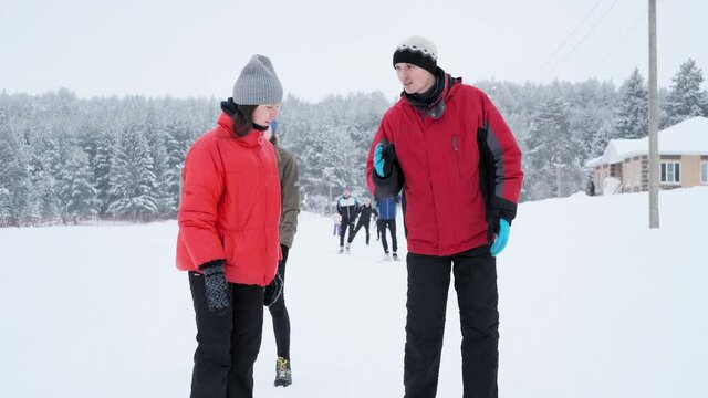 Ski trainer and students. Male trainer explains to his students proper ski technique being outdoor on the cross country ski track