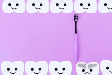 Obraz premium Concept of tooth care. A plastic toothbrush and cartoon teeth cut out of felt on a blue background. Flat lay. Copy space