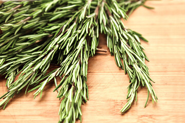 Rosemary branches lie on a wooden Board. Concept of various herbs and seasonings for meat, cooking delicious food using seasonings