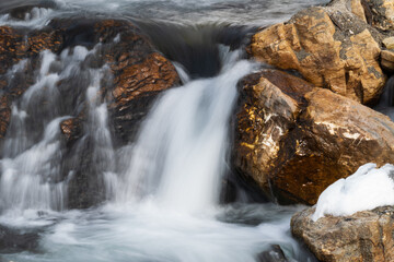 a mountain creek in the spring with water of melting snow, long exposure water photography