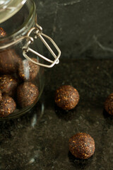 Cocoa raw energy balls with nuts and chia on dark background