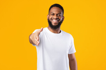 Happy African American Man Offering Hand For Handshake, Yellow Background