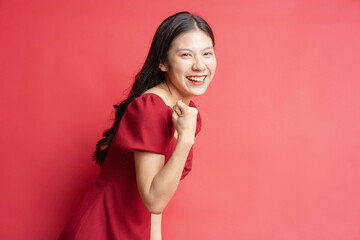 Portrait of young girl wearing red dress with expression on background