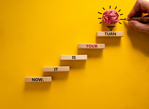 Business concept growth success process. Wood blocks stacking as step stair on yellow background, copy space. Businessman hand. Words 'now, it is your turn'. Conceptual image of motivation.