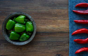 Food background. Green and red bell peppers, green chili on the wooden table.