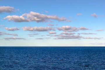 Naklejka na ściany i meble Calm blue Baltic sea with light white clouds and horizon over water in the far distance